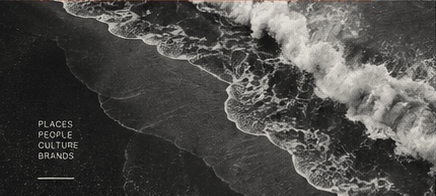 Aerial view of waves reaching a dark coast